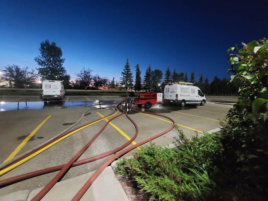 Rotaflow crew running a fire hydrant flow test at dusk with service vans